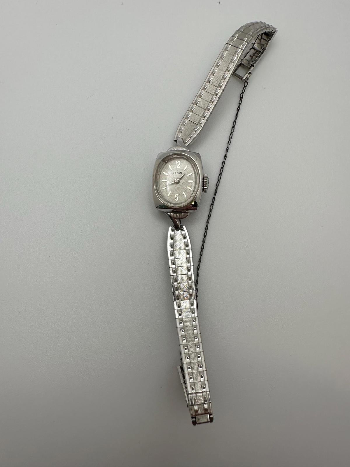 Silver wristwatch with a chain strap on a gray background
