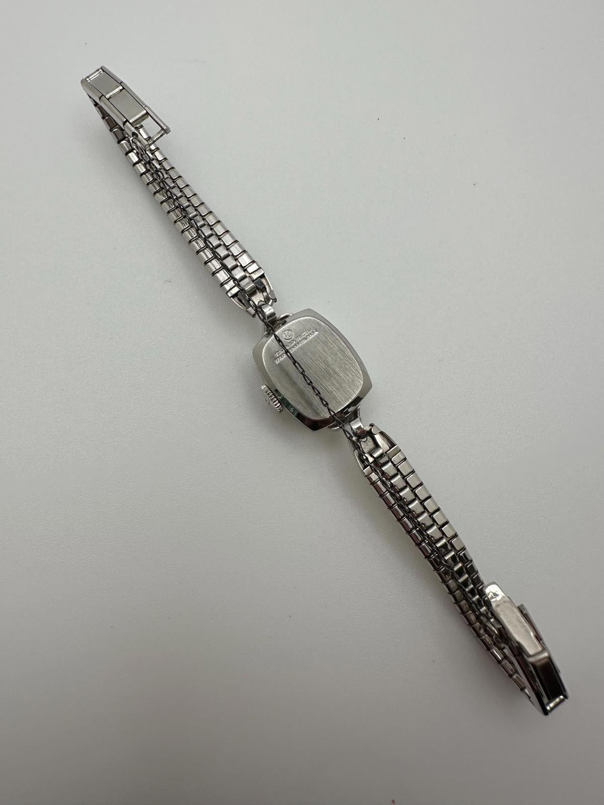 Silver watch on a light gray background